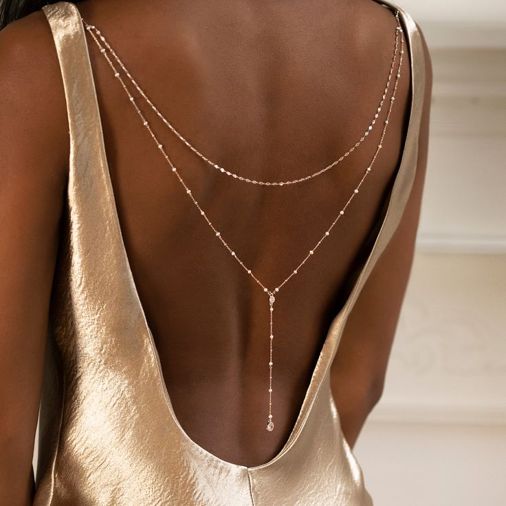 The ultimate backdrop jewelry for a V-shape low back dress! This delicate Pearl Y Lariat Cubic Zirconia chain back jewelry in Gold is the perfect accessory. Easy to wear, clips onto your dress. 14K Gold Vermeil Freshwater Pearls, 3mm Cubic Zirconia Crystals, 5mm + 7mm Hypoallergenic, lead and nickel free Back Length 12 in (30 cm) Note:You must attach loops to dress in order to clip back jewelry #NBC084 2-3 business days Pearl Backdrop, Jóias Body Chains, Backdrop Necklace, Backdrops Necklace, Low Back Dresses, Body Chains, Back Necklace, Necklace Bridal, Back Jewelry