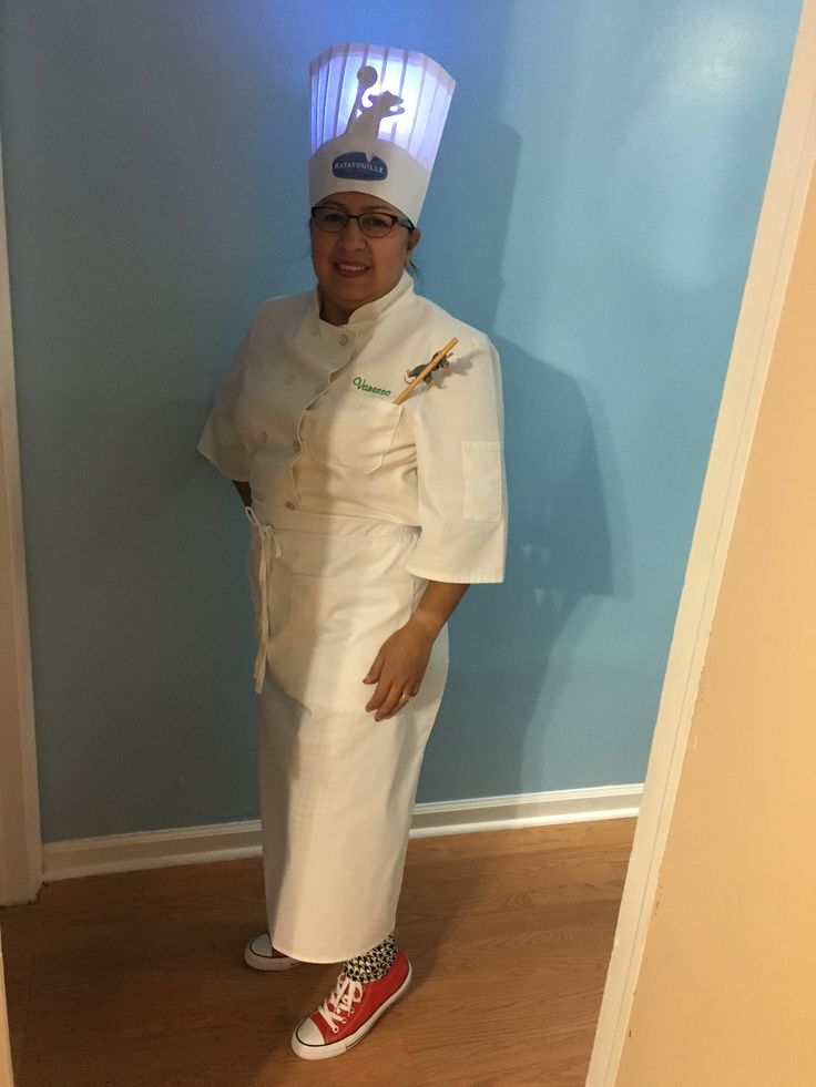 a woman dressed as a chef standing in front of a blue wall