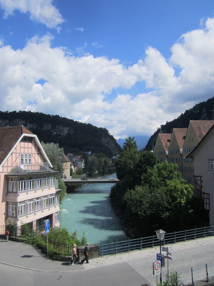 a river running through a small town surrounded by mountains