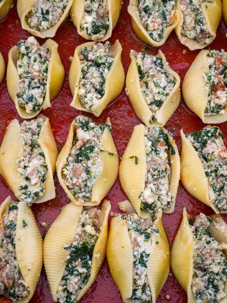 several stuffed shells with spinach and cheese on top