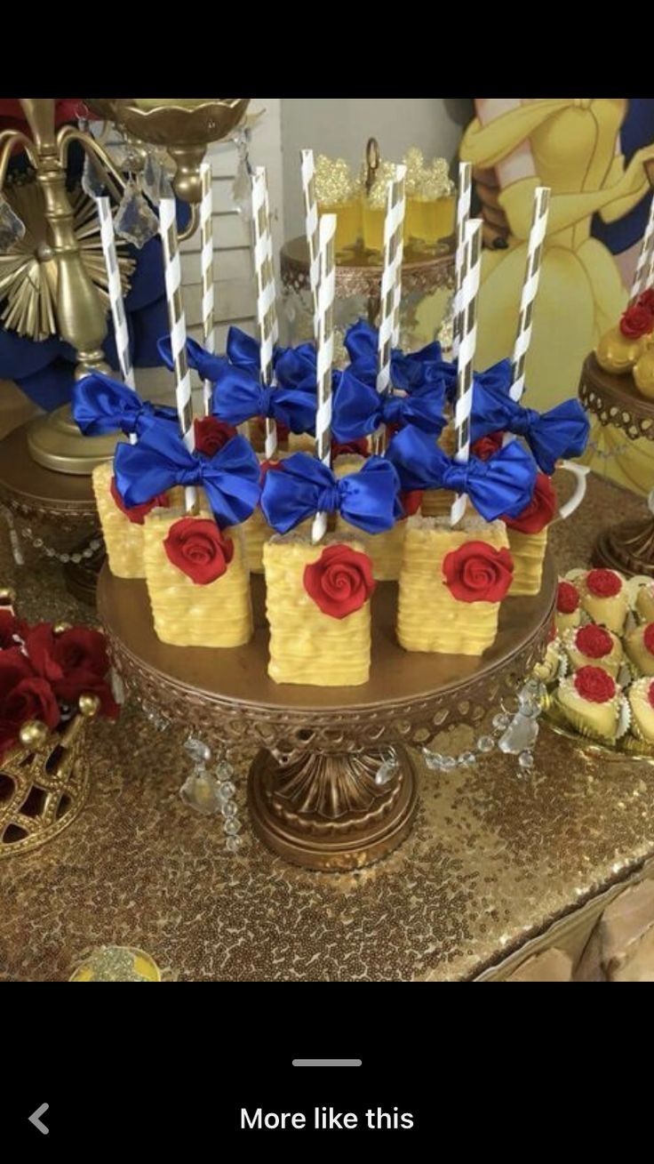 some cupcakes with candles in them are on a cake platter at a beauty and the beast birthday party