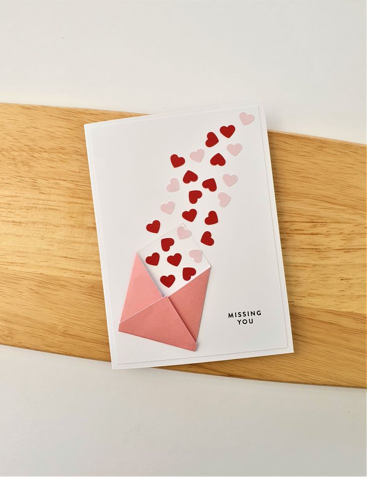 a valentine's day card with hearts coming out of an origami envelope