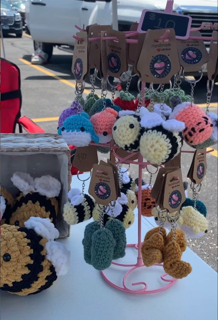 there are many crocheted items on the table and one is hanging from it's stand