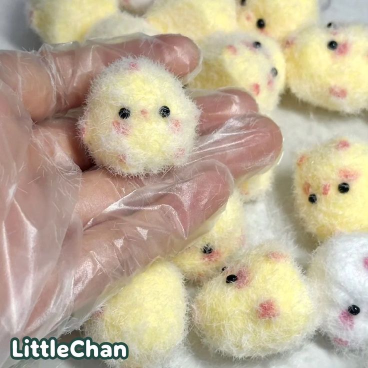 a hand holding a plastic bag over small yellow chicks