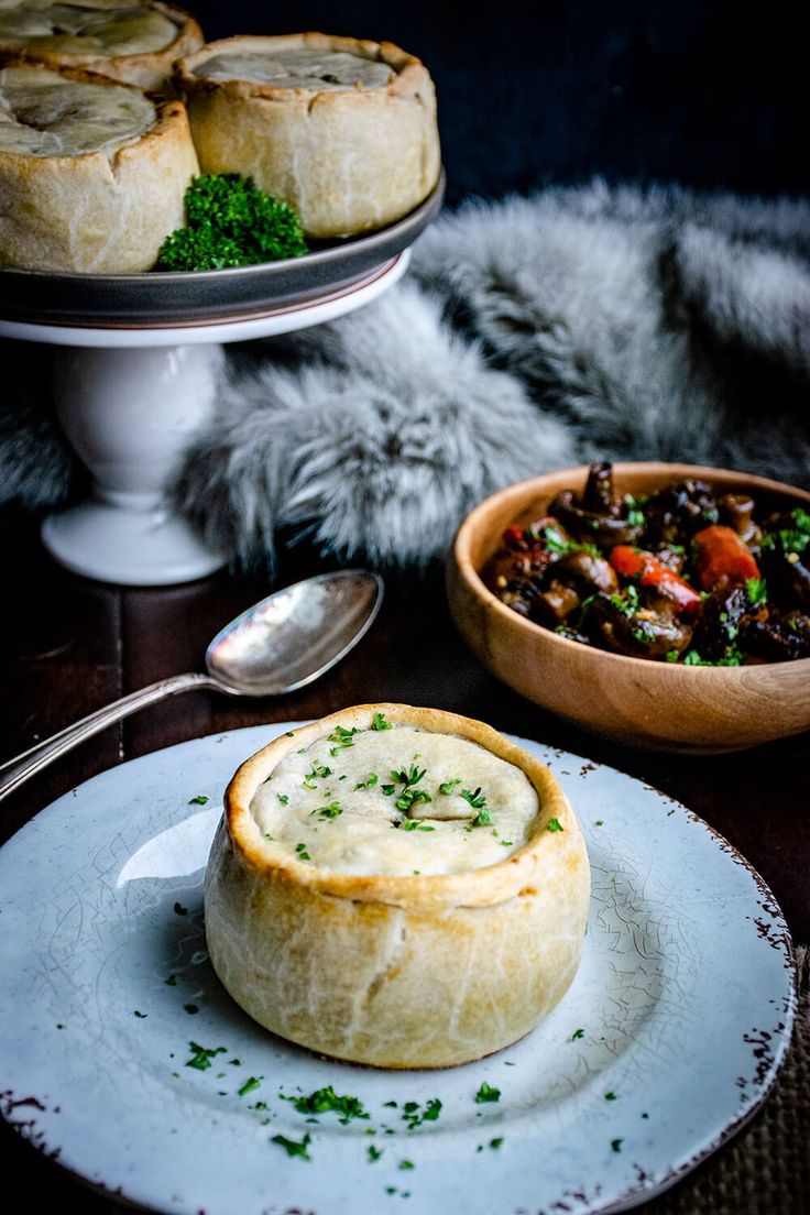 a plate with some food on it next to a bowl of soup and a serving dish