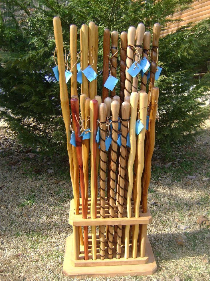 several wooden sticks are stacked up in a holder on the grass with blue tags attached to them