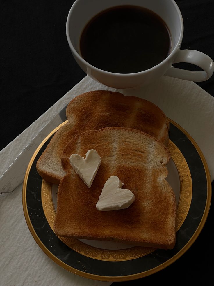 two pieces of toast with butter on them and a cup of coffee