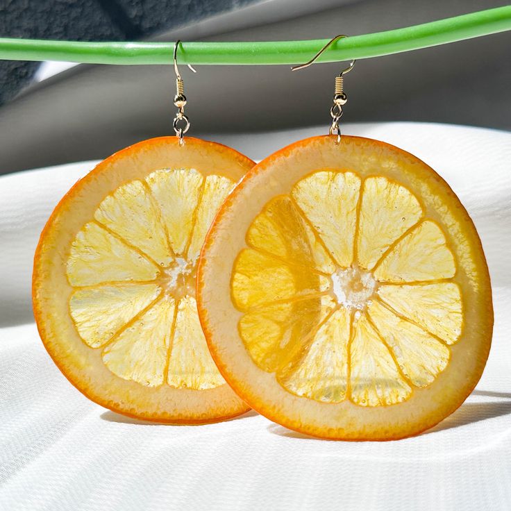 Hello. Welcome to my shop:) Christmas SaleBUY 2 GET 1 FREE: 1~If you order two pairs of earrings, you will receive a free pair of dry-pressed real flower or fruit earrings. 2~If you want designated free earrings, please send me a message tell me which one you want. The pressed orange earrings are made of resin and real orange.  - Handmade item - size: About 70*70mm - Materials: Gold/Silver Plating, Resin, Orange Slice - Real orange slice, Resin encased design - June birthday personality gift 🎁 Gift Box Wrapping: Unique rings are suitable for women. Wife, Girlfriend, Mother, Grandmother, Daughter, Women Friends and yourself. 🍃 Free shipping: The package needs about 3-10 days to get all over the world. Please feel free to contact me with any questions :) Aretes Aesthetic, Personality Gifts, Vegan Jewelry, Orange Slice, Dried Oranges, Fruit Jewelry, Real Fruit, Fruit Earrings, Orange Earrings