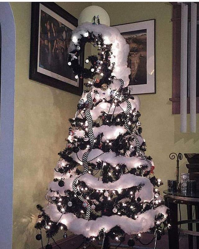 a white christmas tree with black and silver ornaments in the shape of an xmas tree