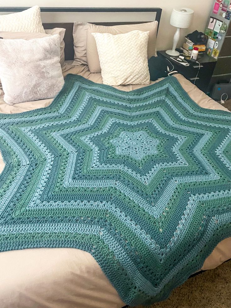 a crocheted blanket sitting on top of a bed