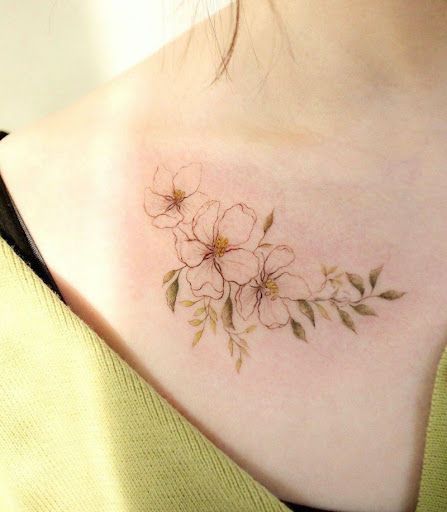 a woman with a tattoo on her chest has flowers drawn on it's back