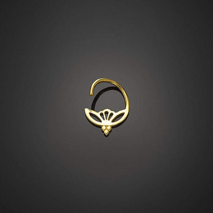 a gold ring with a flower design on the middle, and a small diamond in the middle