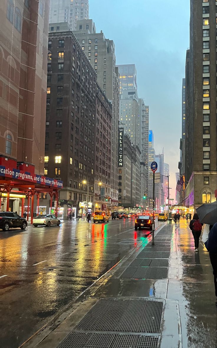 people with umbrellas are walking down the street in the rain on a rainy day