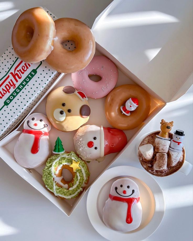 doughnuts and donuts are arranged in a box on a table with other items