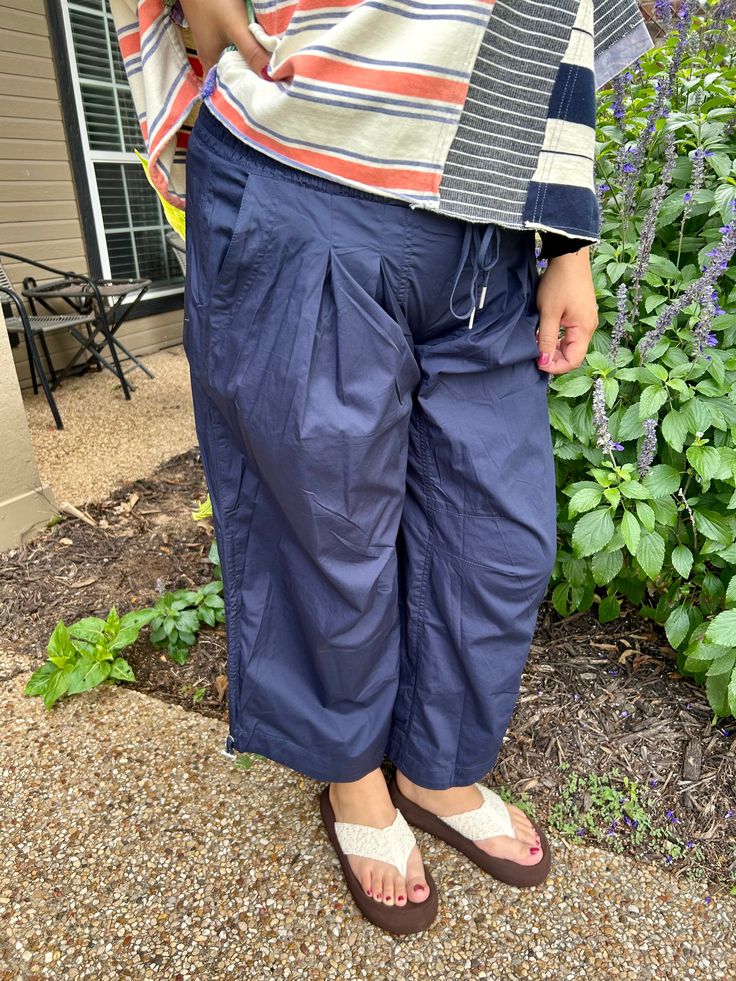 Super relaxed fit navy slightly cropped pants featuring a smocked waist with a pull drawstring closure, two side hip pockets, added pleats for detail, two back pockets and a drawstring cinch cuff on the sides of legs. so super comfy! Anna is 5:7 and weighs 185, she is wearing a large Casual Pull-on Capris, Relaxed Fit Cotton Capris With Pull-on Style, Relaxed Fit Cotton Pull-on Capris, Casual Capris With Elastic Waistband, Casual Pull-on Cropped Leg Capris, Relaxed Fit Cotton Bottoms With Gathered Waist, Cotton Bottoms With Relaxed Fit And Gathered Waist, Spring Relaxed Fit Parachute Pants With Drawstring, Relaxed Fit Capris With Side Pockets