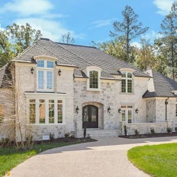 a large white brick house with lots of windows