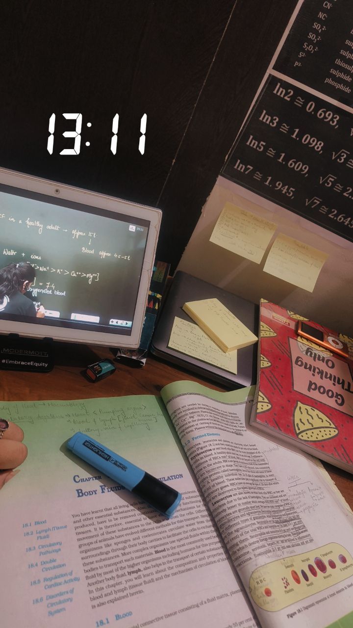 an open book sitting on top of a desk next to a computer monitor