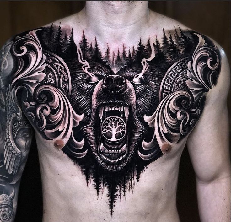 a man's chest with a bear tattoo on it