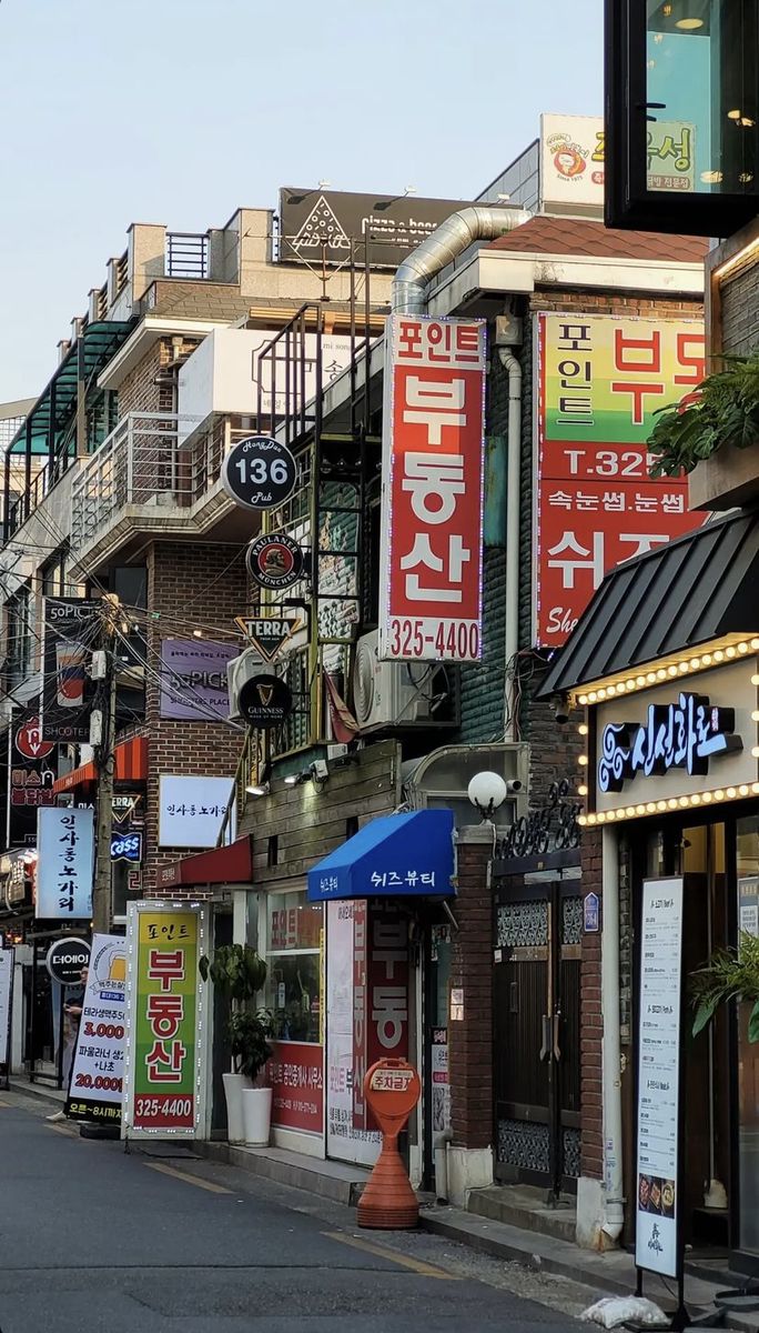 a city street lined with lots of buildings covered in signs and advertisements on the side of it