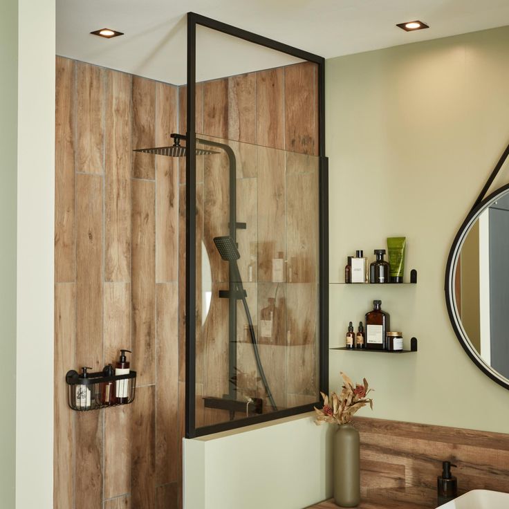 a bathroom with wooden walls and a glass shower door that opens up to the bathtub