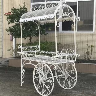 a white metal carriage sitting in front of a building