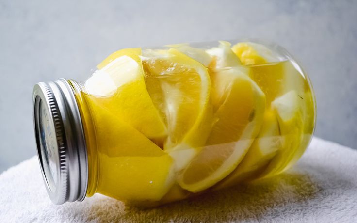 a jar filled with sliced lemons on top of a towel