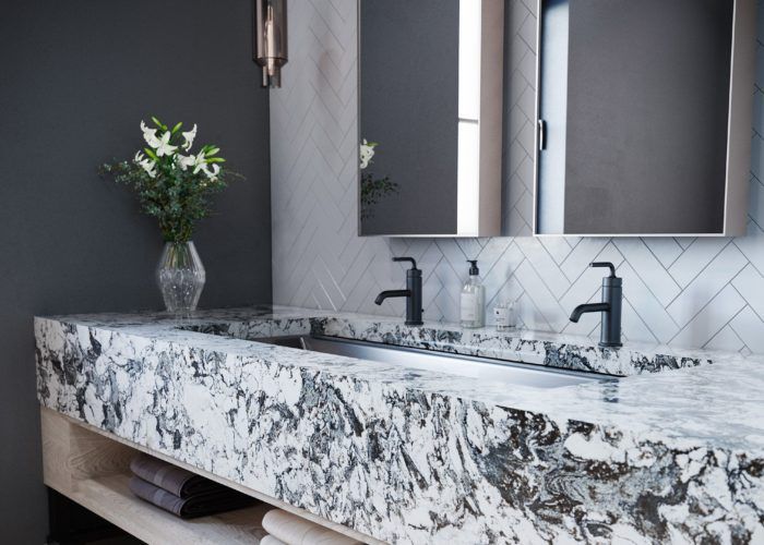 a bathroom with marble counter tops and double sinks