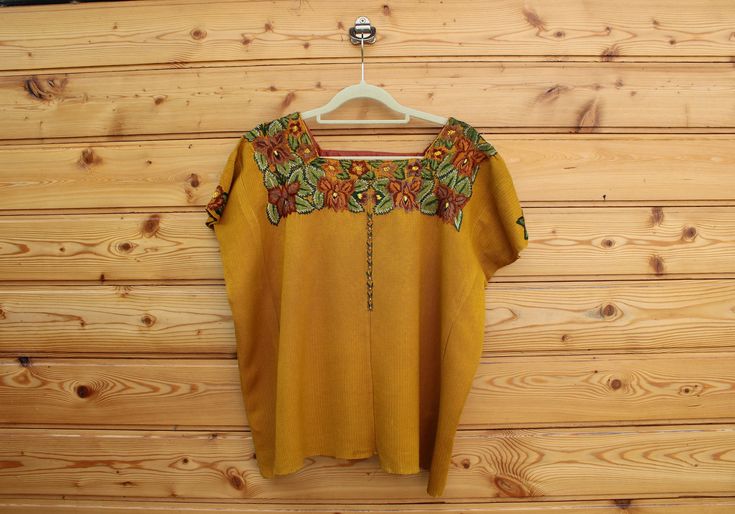 The Huipil is a traditional Mayan blouse. The Huipil has traditional patterns representing the respective town that the wearer (or piece) comes from. This piece is from the North of Guatemala, handmade and embroidered with orange flowers in varying shades. *gray no longer available, photo is for fitting purposes only* Bohemian Tops With Traditional Patterns For Summer, Traditional Tops With Festive Patterns, Traditional Tops With Traditional Patterns For Festivals, Folk Style Cotton Top With Traditional Patterns, Traditional Tops With Motif For Spring, Bohemian Blouse With Traditional Patterns For Ceremonies, Traditional Summer Tops With Traditional Patterns, Traditional Tops With Summer Patterns, Festival Tops With Traditional Patterns