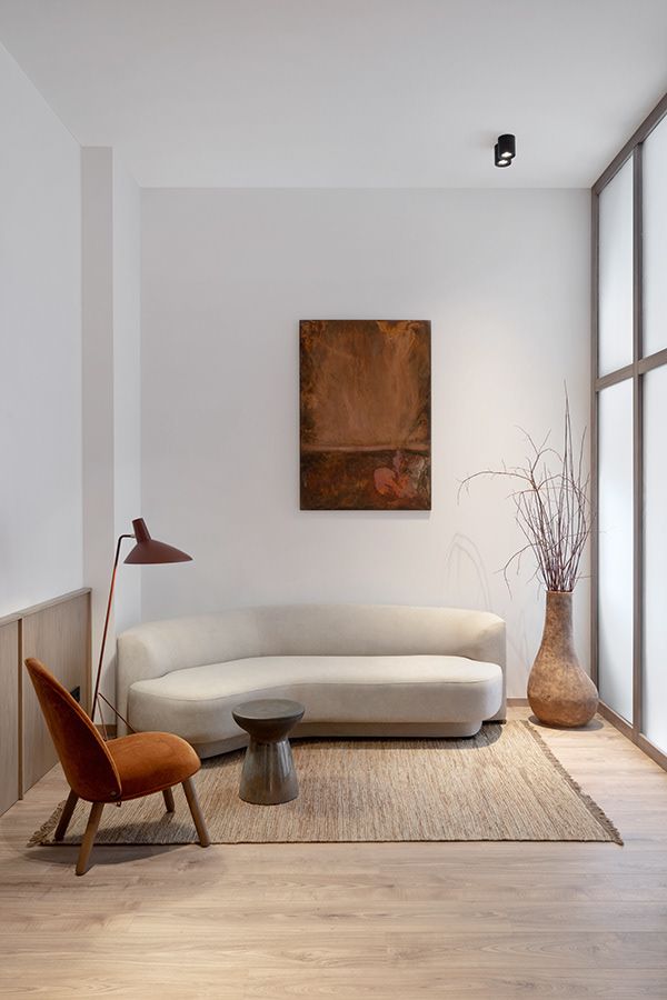 a living room filled with furniture and a painting hanging on the wall above it's windows