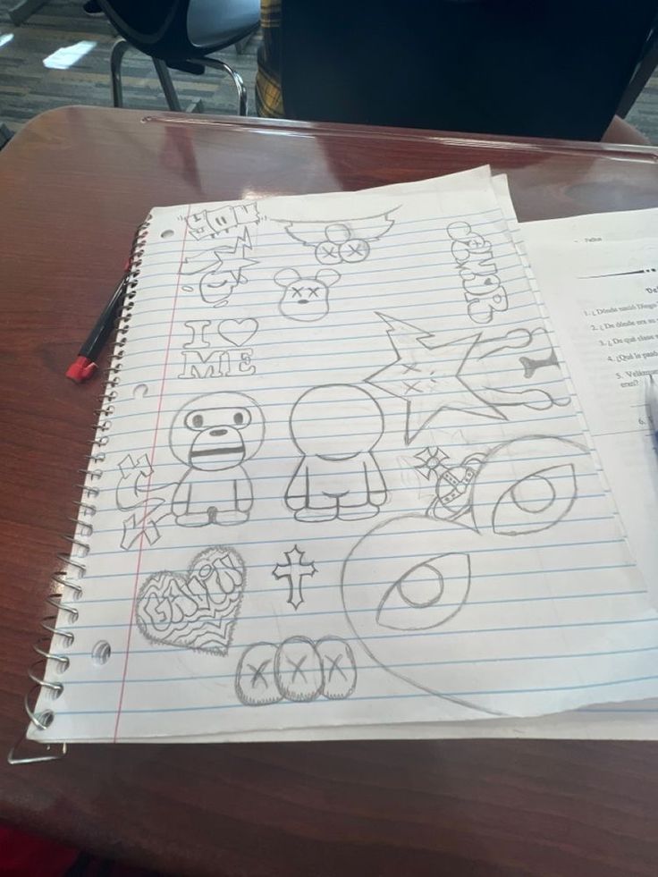 a notebook with drawings on it sitting on a desk