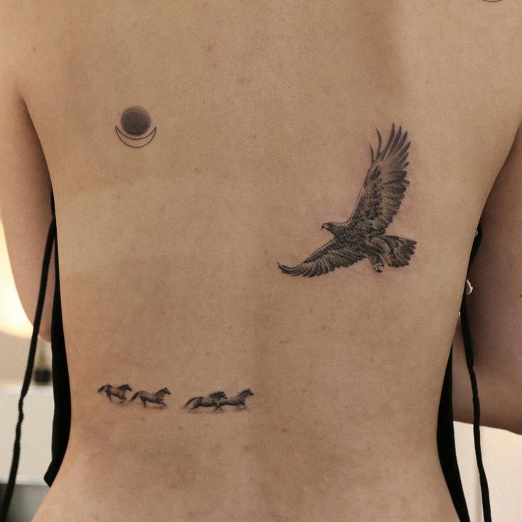 a woman's back with an eagle and birds tattoo on her left side ribcage