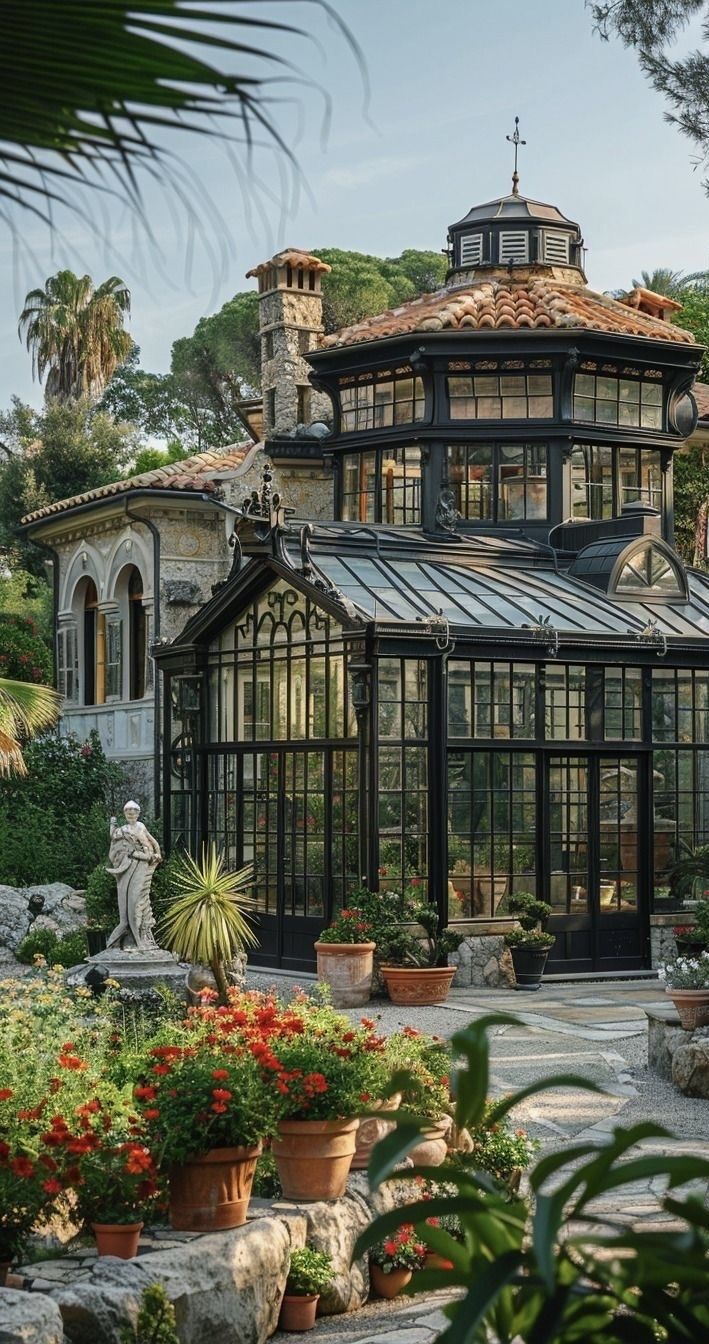 a large glass house surrounded by lots of plants