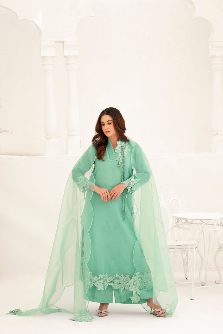 This light green Shalwar Kameez features a mint green organza lined shirt with lace appliqué all over the body and chaak, accompanied by a matching organza cutwork dupatta. The delicate lace adds an elegant touch to the traditional style, making this outfit perfect for any formal occasion. 3-Piece Suit Green Organza Unstitched Suit For Eid, Festive Green Organza Salwar Kameez, Anarkali Lawn Suit With Lace Work In Organza, Elegant Green Churidar With Resham Embroidery, Green Organza Salwar Kameez For Eid, Green Dabka Lawn Suit For Wedding, Elegant Green Churidar For Eid, Elegant Pista Green Organza Unstitched Suit, Green Organza Sharara With Dabka Details