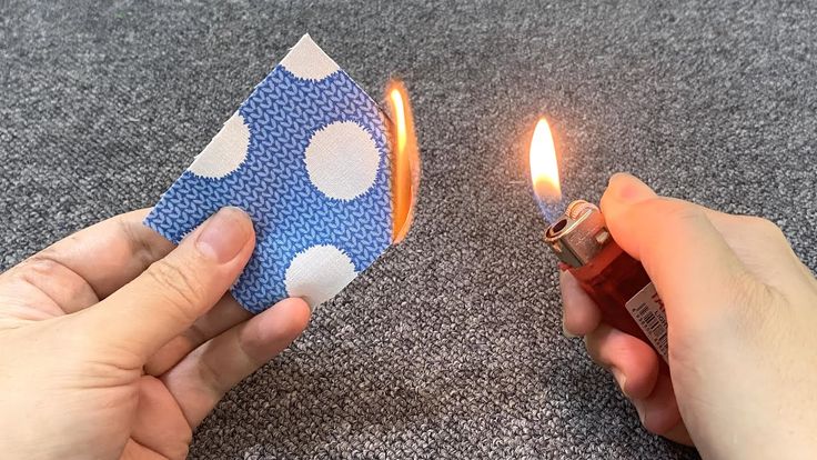 someone is lighting a lighter in the shape of a polka dot paper bag with one hand