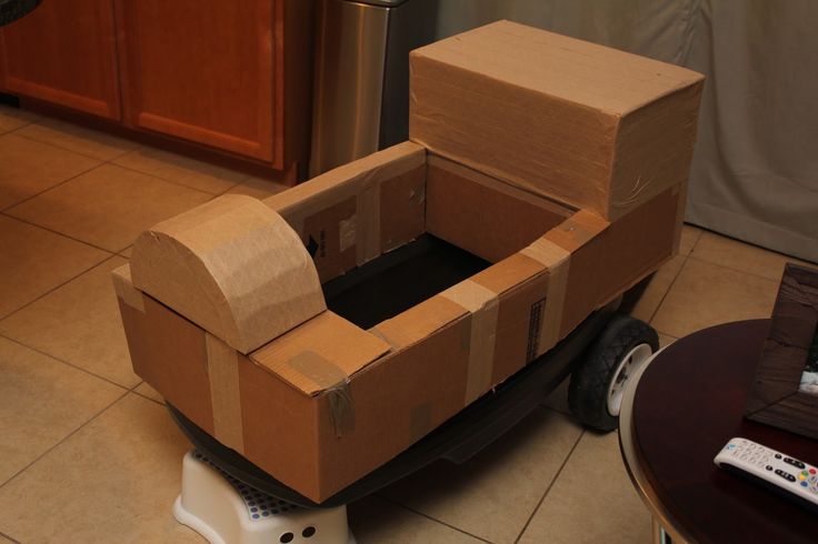 cardboard boxes are stacked on top of a small cart in the middle of a kitchen