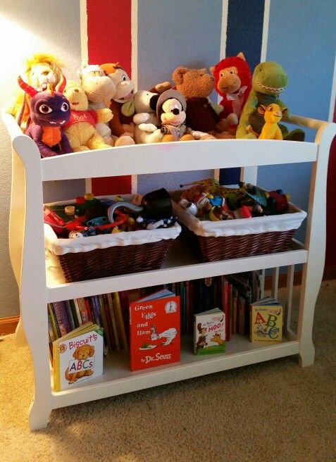 a book shelf with stuffed animals and books on it in a child's room