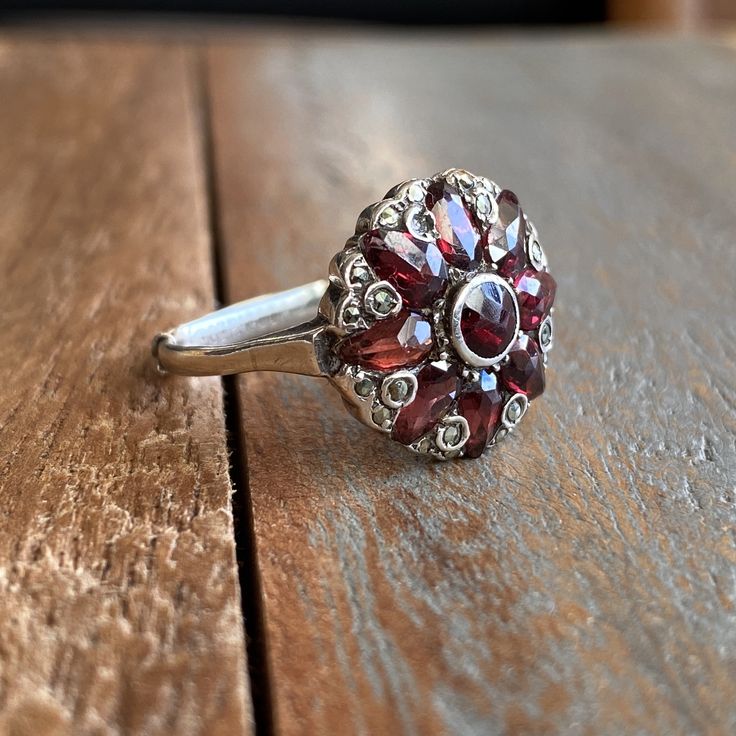 Antique Sterling Silver Garnets and Marcasites Cluster Ring Multi Stoned  Antique silver ring with faceted round garnet in the centre, tear shaped garnets around it and small marcasites, from Art Deco era c.1920s It Has a 935 mark at the bottom of the band, most likely a European Continental silver mark. Great antique condition. Measurements  US: 7/8 UK: O/P Ruby Ring With Rose Cut Diamonds, Vintage Garnet Rings With Accent Stones, Round Multi-stone Ruby Ring With Garnet, Vintage Garnet Ring With Center Stone, Vintage Garnet Cluster Ring With Gemstone, Vintage Garnet Rings With Rose Cut Diamonds, Silver Garnet Ruby Ring With Center Stone, Victorian Silver Ring With Garnet, Antique Silver Garnet Jewelry