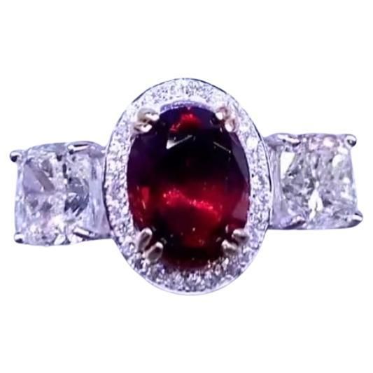 An exclusive ring in contemporary design, so modern and sophisticated . This captivating ring is crafted to perfection . Ring showcases the vibrant allure of the brillant red ruby , enhanced by the radiant sparkly of diamonds. Immerse yourself in the luxurious beauty of this mesmerizing piece, exuding elegance and charm. Stunning ring come in 18k gold with a Natural Untreated Mozambique Ruby of 2,00 carat, vibrant Pigeon Blood Red color , perfect oval cut, and 2 pieces of GIA certified Natural Diamonds in round brillant cut of 1 +1 carat, I color VS clarity. Investment piece. Handcrafted by artisan goldsmith. Wholesale Price. Extremely HIGH QUALITY Product. Shop with Confidence. We can offer free worldwide shipping. Mozambique Ruby, Blood Red Color, Blood Red, Red Ruby, Three Stone Rings, Gia Diamond, 1 Carat, Three Stone, Mozambique