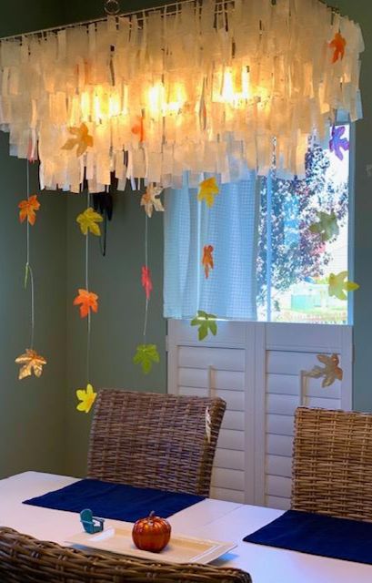 a dining room table with chairs and a chandelier hanging from the ceiling