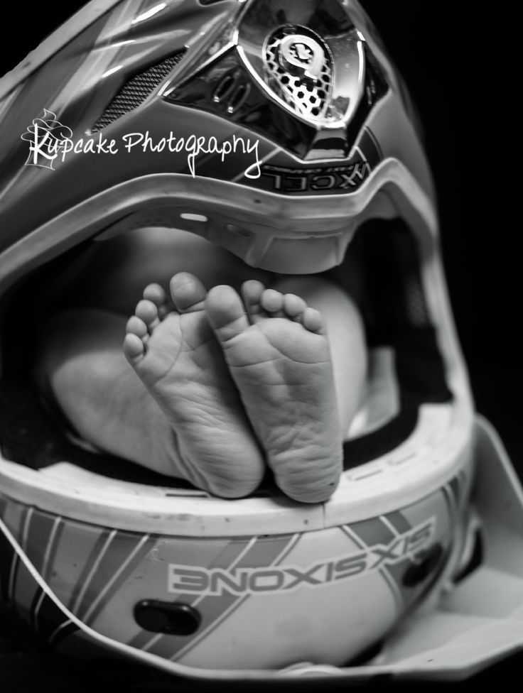 a black and white photo of a baby's feet in a helmet