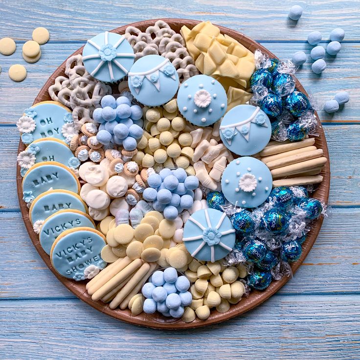 a platter filled with cookies and candies on top of a blue wooden table