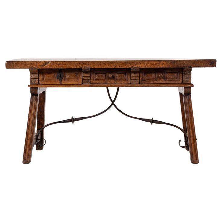 an old wooden table with two drawers on one side and wrought iron legs at the bottom