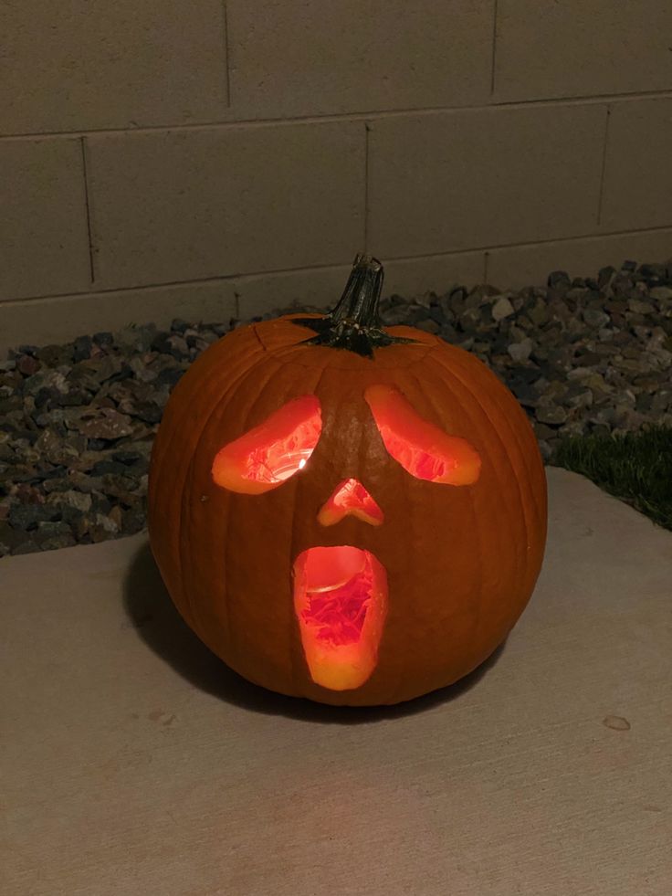 a carved pumpkin with the face of a person's head and eyes painted on it