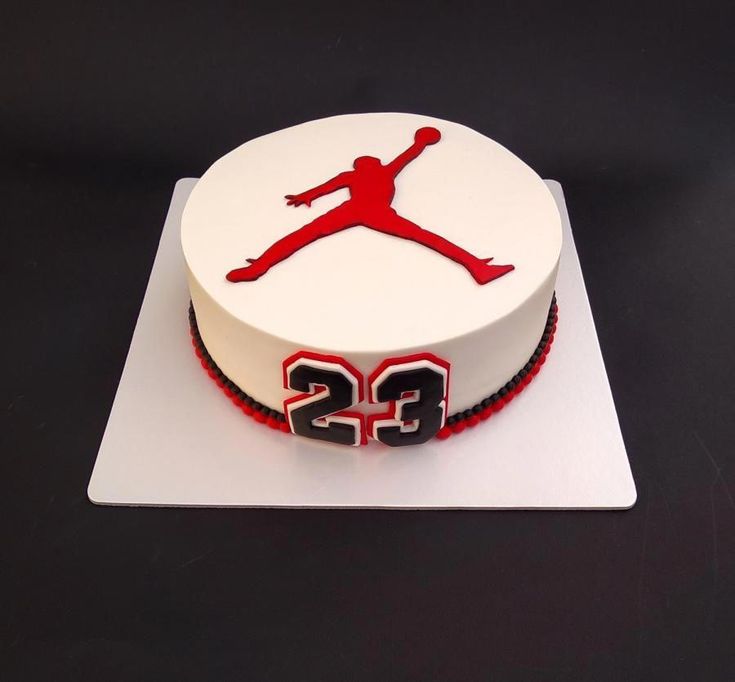 a white cake with a red and black design on the top that says 25 is displayed