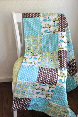 a chair with a quilt on it and a blanket draped over the back of it