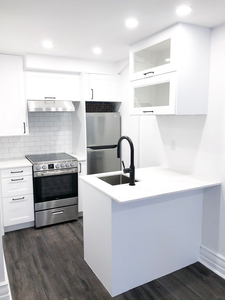 an empty kitchen with white cabinets and stainless steel appliances