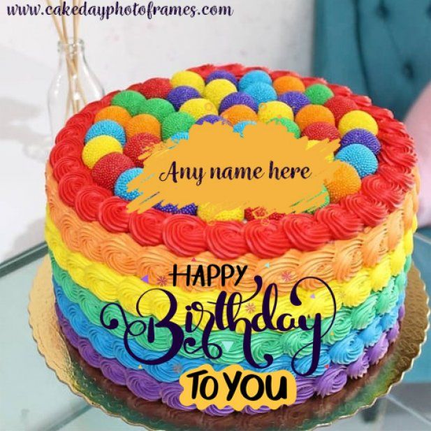 a rainbow colored birthday cake with name on it