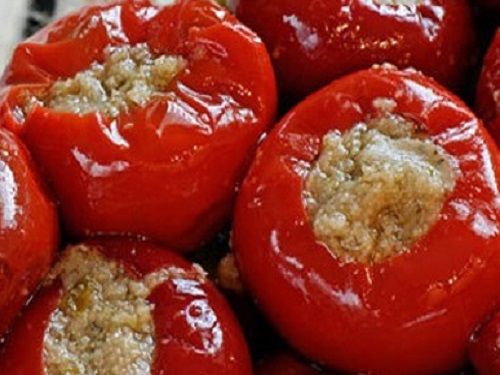 a pile of red stuffed tomatoes sitting on top of a table