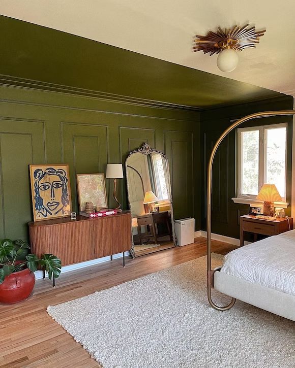 a bedroom with green walls and wooden floors