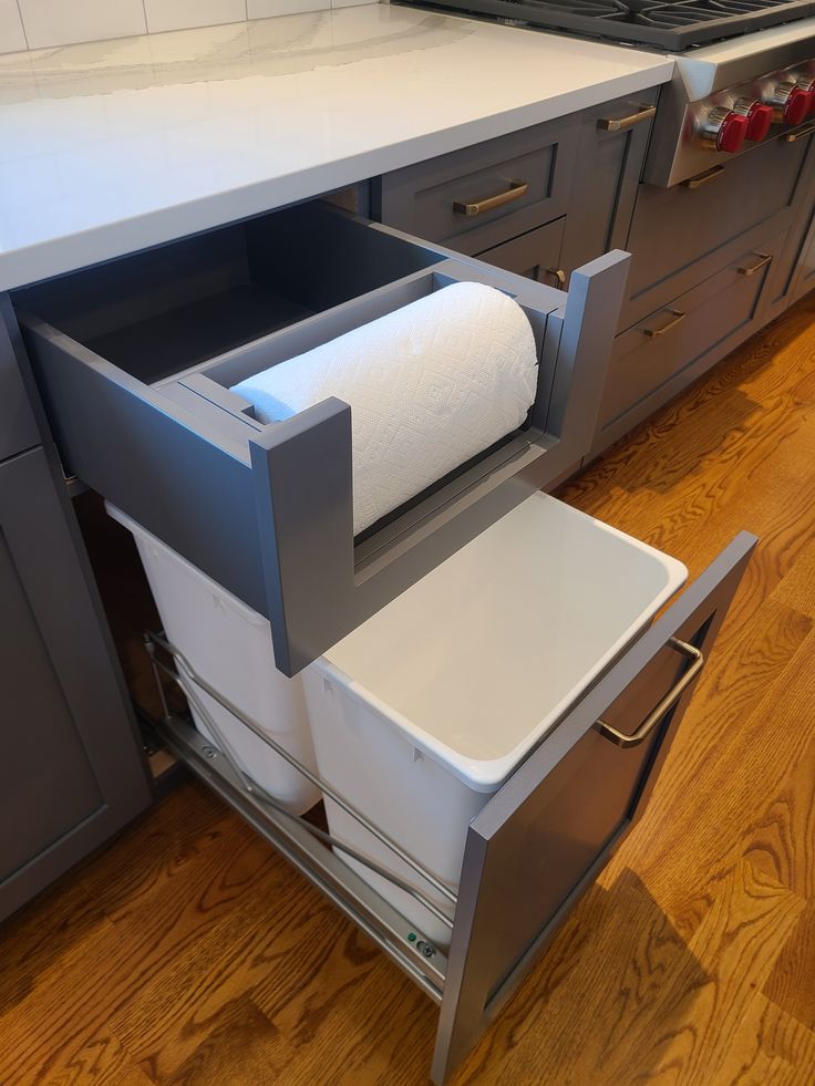 a roll of toilet paper is sitting in the drawer on top of a cabinet that's open